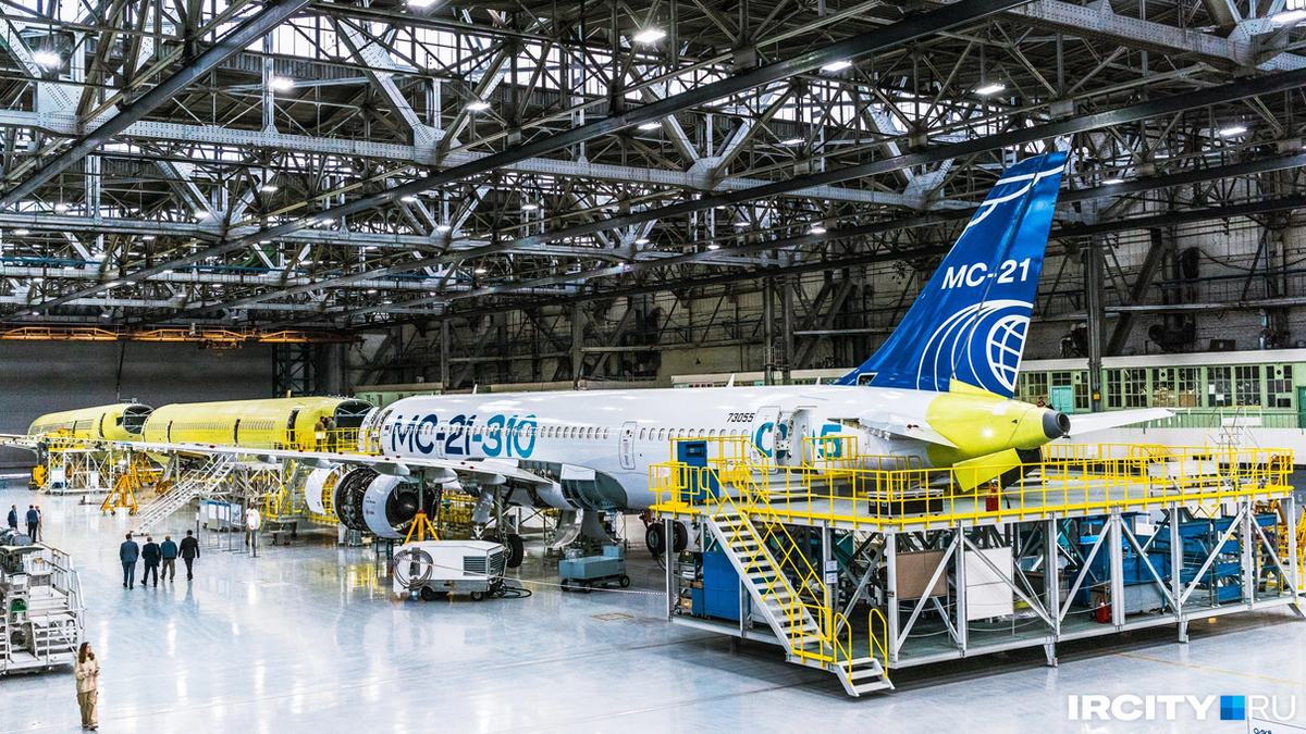 На фото: сборка отечественного магистрального самолета МС-21 на Иркутском авиационном заводе, который с недавних пор является филиалом ПАО «Яковлев» и входит в госкорпорацию «Ростех». Источник фото: https://ircity.ru/text/transport/2024/08/26/73995017/