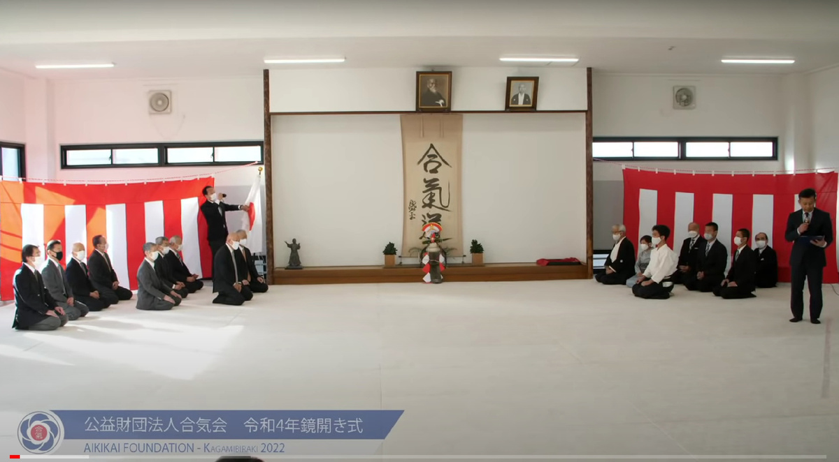 Кагами Бираки в главном додзё Айкидо Айкикай, 2022. Справа в первом ряду сидят Дошу Моритеру Уэсиба (ближе к стене) и его сын Митсутеру Уэсиба