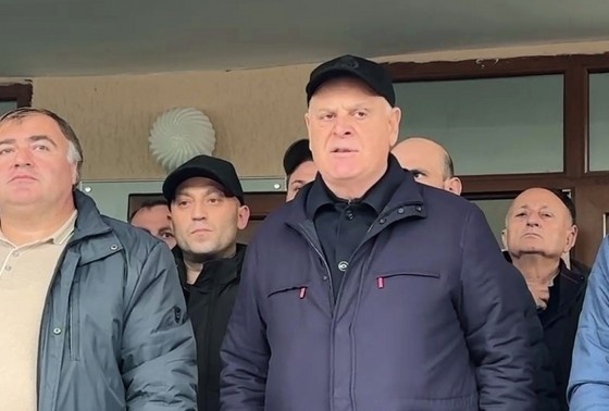    Президент Абхазии Аслан Бжания (справа) выступает перед своими сторонниками у здания школы в селе Тамыш