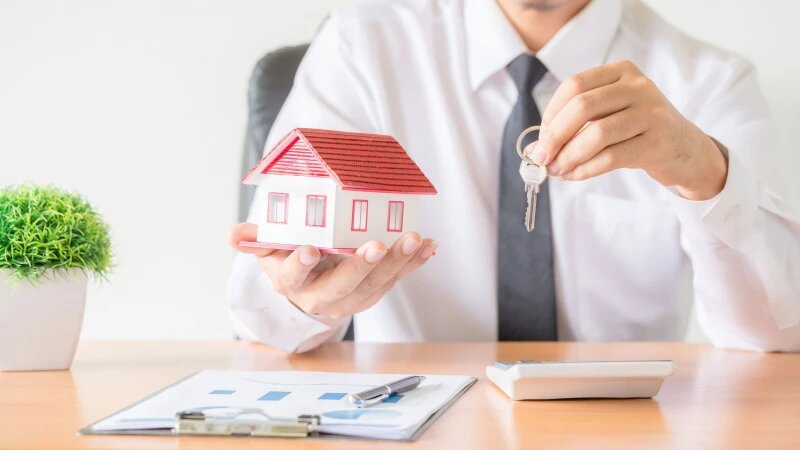     Мужчина держит в руках макет дома и ключ. Фото: ru.freepik.com, автор jcomp.