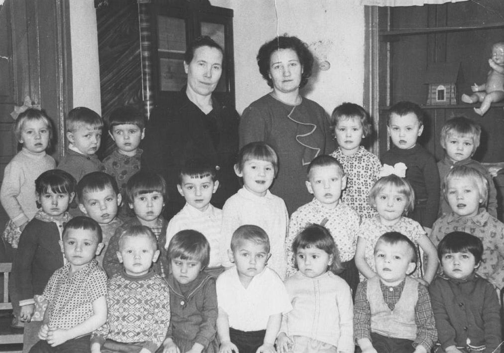 нам по 4 года. Я рядом с воспитательницей, Валя самая крайняя слева во втором ряду.
