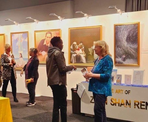 Экскурсоводы рассказывают посетителям выставки истории, лежащие в основе картин. (Фото: minghui.org)