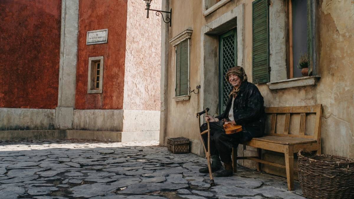    Актер массовки Леонид Агранович (тезка знаменитого режиссера) играет роль бездомного со скрипкой / Фото: Пресс-служба фильма «Буратино»