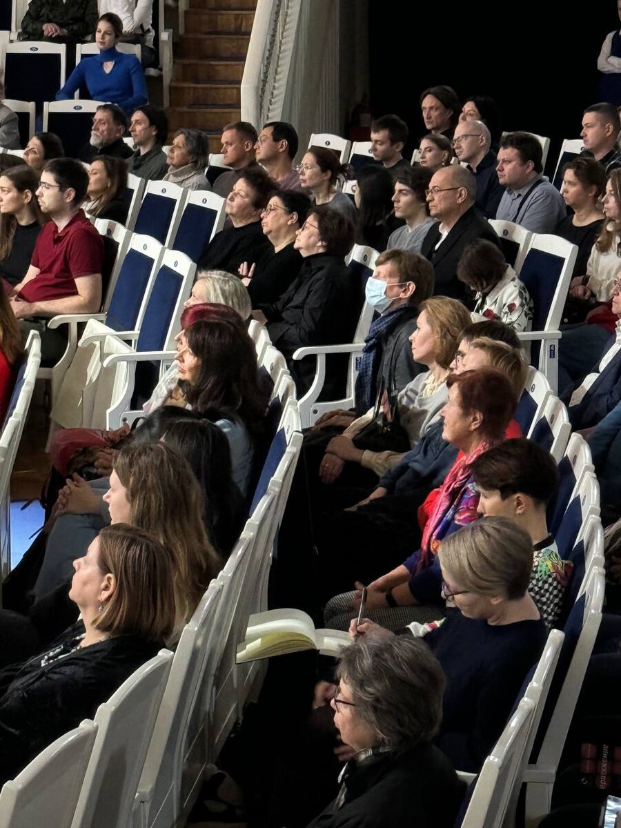 Девушка что-то рисует в зале.