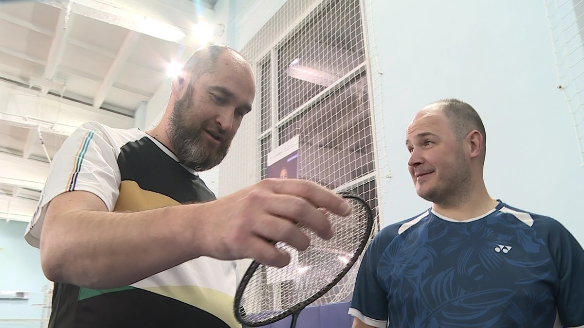 Друзья по бадминтону рассматривают старые ракетки