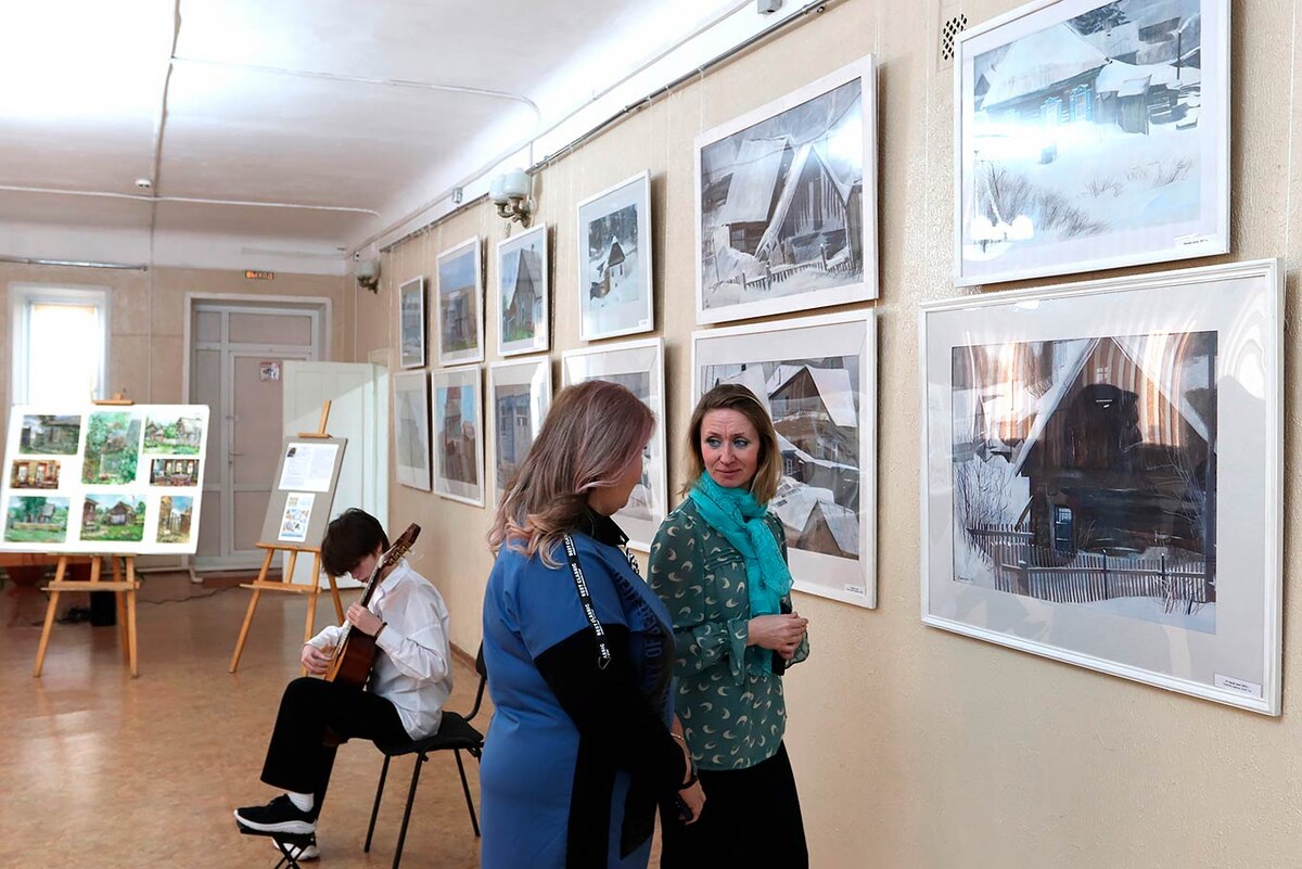 Вероника РЕЗИНКИНА обсуждает с гостьей специфику деревянных построек. Фото Вячеслава ПЕТРОВА.