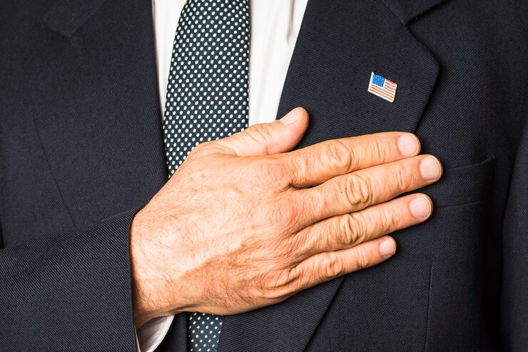 Источник фото: https://ru.freepik.com/free-photo/close-up-patriotic-man-with-usa-badge-his-black-coat-touching-hand-his-chest_4635958.htm#fromView=search&page=3&position=32&uuid=cabc45fe-5dc6-4346-91f8-a1490b0b8037