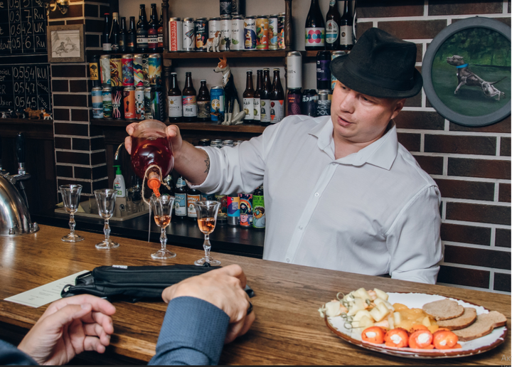 Барная стойка старого здания паба "Полтора питбуля", закрытая закрытое, владелец за барной стойкой (фото взято с официального сайта, https://vk.com/poltora_pitbulya) 