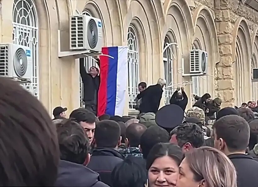  Протестующие вывесили над входом в Народное Собрание флаги Абхазии и России   © РИА Новости