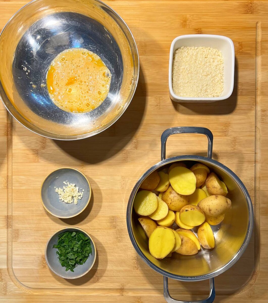 Промойте картофель и разрежьте каждую на две части.Отправьте вариться в подсоленной воде , варите 10 минут после закипания. Разбейте яйцо в большую миску, взбейте и добавьте панированные сухари, размешайте и добавьте фарш. Фарш посолите по вкусу и хорошо промешайте . Чеснок и зелень мелко нарубите .