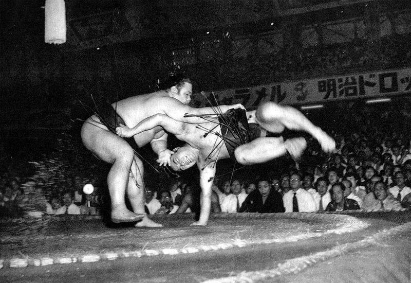    Борцы сумо Адзумафудзи Кинъити (слева) и Точинисики Киётака (справа) борются в Токио в 1953 году /Public Domain