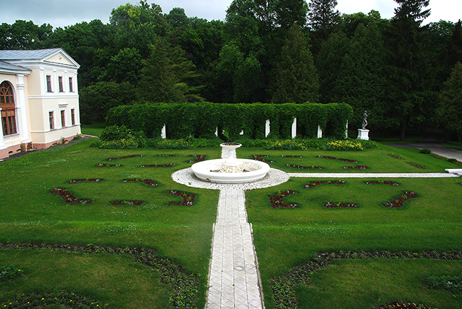 В центре архитектурного комплекса - трехэтажное #здание дворца с одноэтажными флигелями. С угловых балконов к открытой террасе ведут каменные лестницы, а с террасы в парк – широкая гранитная лестница.