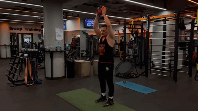 Встаньте прямо. Поставьте ноги на ширине плеч или уже, держите их прямыми. Держите вес на вытянутых руках над головой