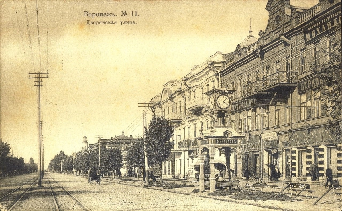 За часами виден магазин купца Михайлова