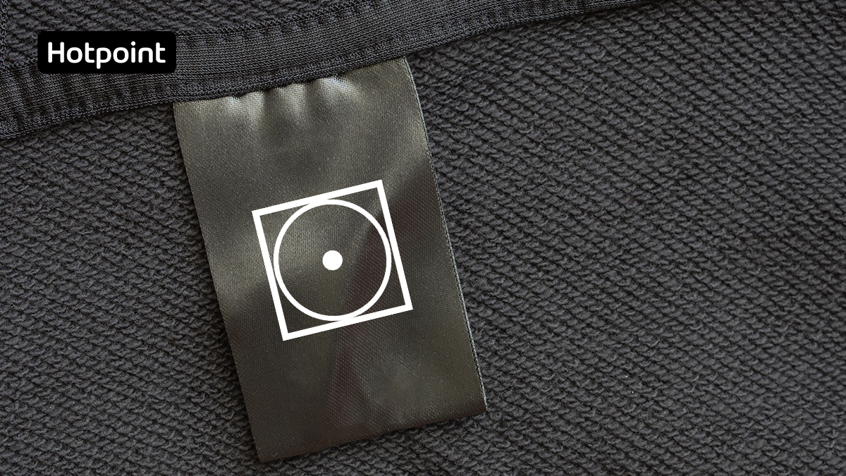 Разрешающий знак на ярлыке для сушки пуховика в сушильной машине