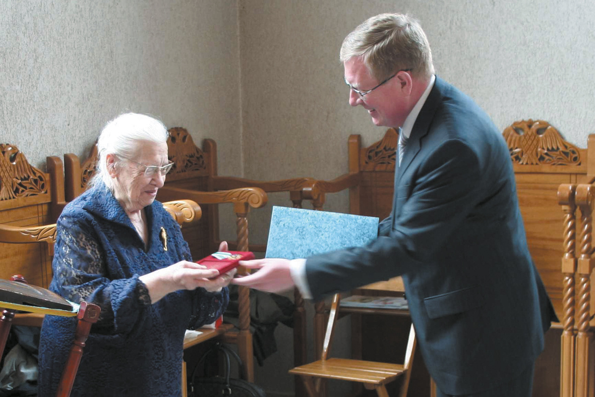 Посол России Игорь Борисович Братчиков вручает художнице и поэтессе Валерии Флориановне Даувальдер Орден Дружбы за большой вклад в укрепление дружбы и сотрудничества между РФ и Швейцарской конфедерацией. Источник https://enakievo.gosuslugi.ru/