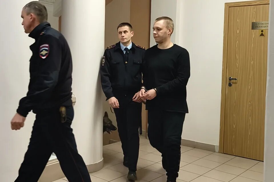 На этом видеозаписе, сделанной в Волгограде, Россия, в понедельник, 25 ноября 2024 года, Никита Журавлёв, справа, в сопровождении полиции направляется в суд на слушание