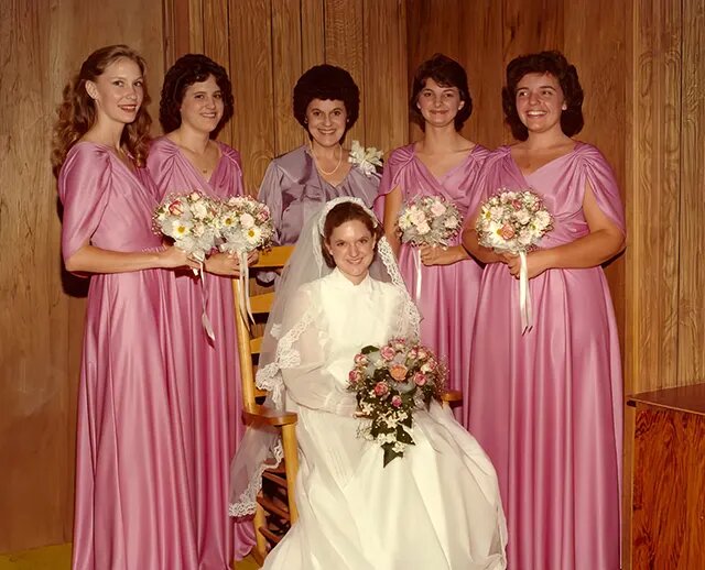 Платья были разработаны, чтобы сделать незабываемое представление, невесты шли к алтарю в платьях, которые были не чем иным, как театральными, с драматическими высокими кружевными вырезами, объемными рукавами-фонариками, струящимися юбками и замысловатыми украшениями.
Ни одна свадьба 1980-х годов не была бы полной без фирменных причесок той эпохи , которые часто соперничали с платьями по объему и драматизму.