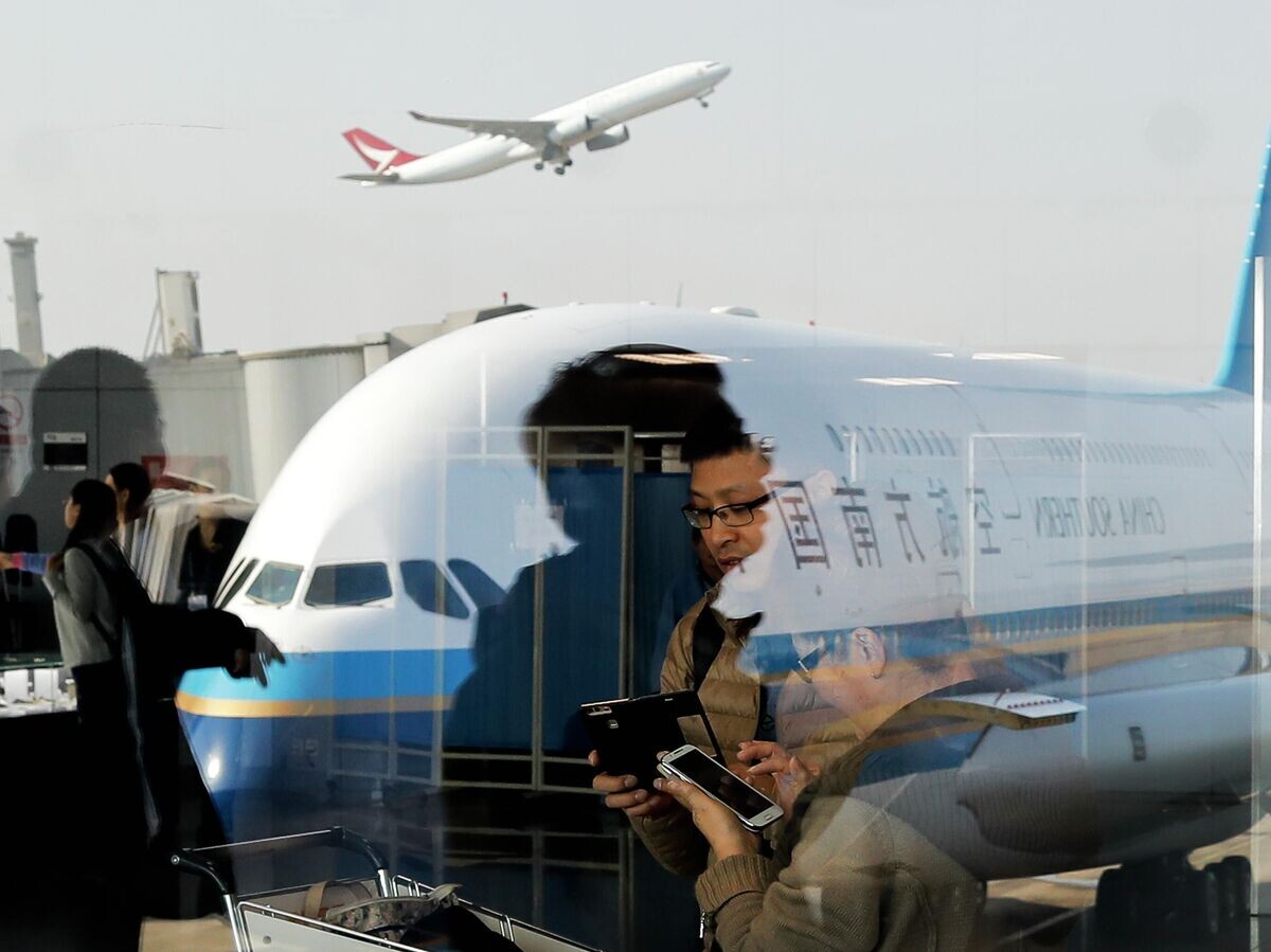    Пассажиры в аэропорту Пекин Шоуду© AP Photo / Andy Wong