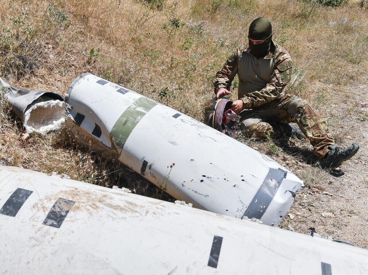    Российский специалист изучает фрагменты ракет ATACMS© РИА Новости