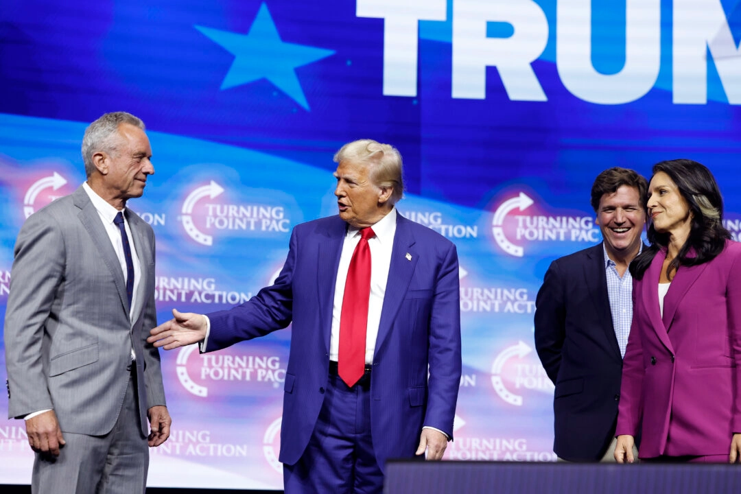 Роберт Ф. Кеннеди-младший, кандидат в президенты от Республиканской партии, бывший президент Дональд Трамп, политический комментатор Такер Карлсон и бывшая конгрессвумен - республиканка от  Гавайев Тулси Габбард выступают на сцене во время предвыборного митинга Turning Point Action на арене Gas South в Дулуте, штат Гавайи, 23 октября 2024 г. Anna Moneymaker/Getty Images.