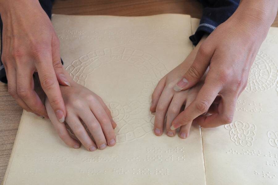 Учитель помогает ребенку осваивать чтение по системе Брайля в специализированной школе для слепых и слабовидящих детей
Фото: Александр Кондратюк / РИА Новости