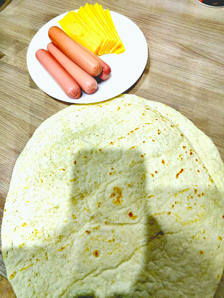 На каждую лепёшку положила сыр и сосиски.