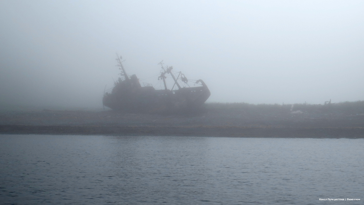 В тумане рыбацкое судно на берегу похоже на потерпевшее кораблекрушение старинное парусное...