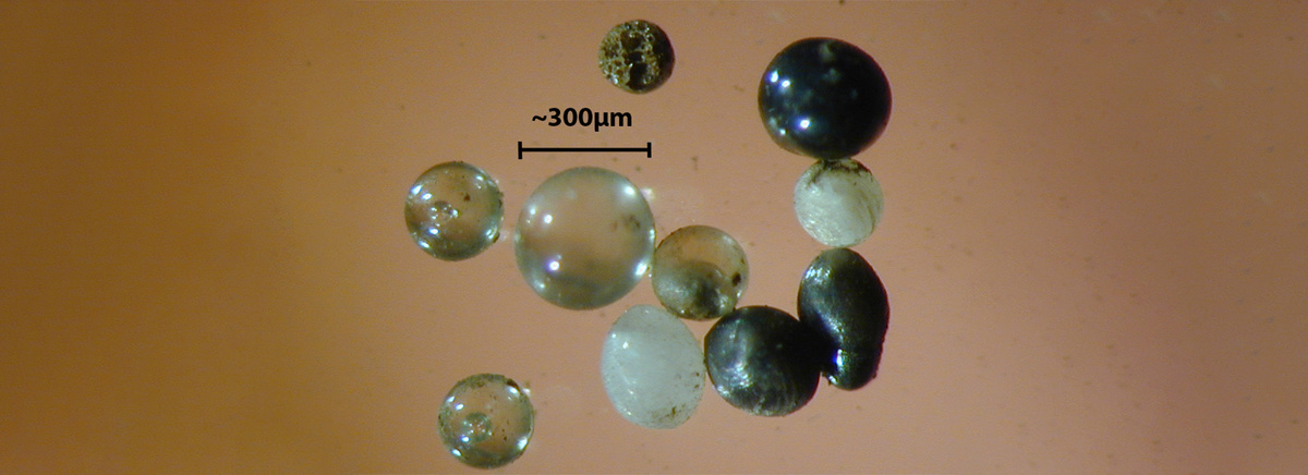 Микрометеориты под микроскопом. Фото: взято из en.wikipedia.org