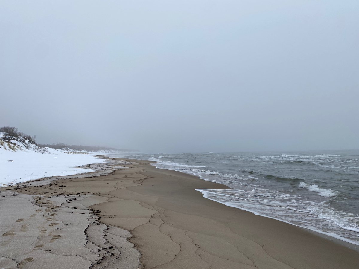 Непокрытое льдом море, песок и снег