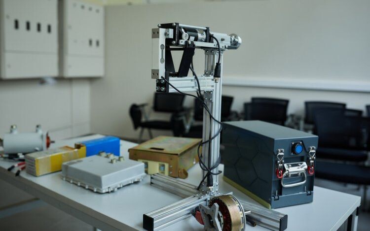 Комплект оборудования на столе ― элементы электрической силовой установки для беспилотных летательных аппаратов и стенд для исследования винтомоторной группы, разработанные в ПИШ МАИ. Фото: Елена Либрик / «Научная Россия»