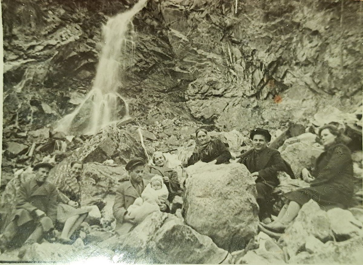 Фотография 1946 года. Руководство вольфрамового прииска у водопада Чертова мельница в долине реки Аксаут. Мужчина, который держит на руках ребенка – начальник рудника Очкасов. Крайняя справа бабушка Таня, левее от нее дед Иван.