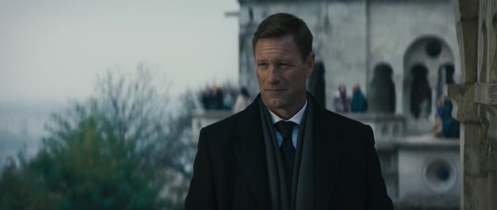 Кадр из фильма "Резидент" (2024). Бен Малой (Аарон Экхарт) на задании в столице Венгрии.