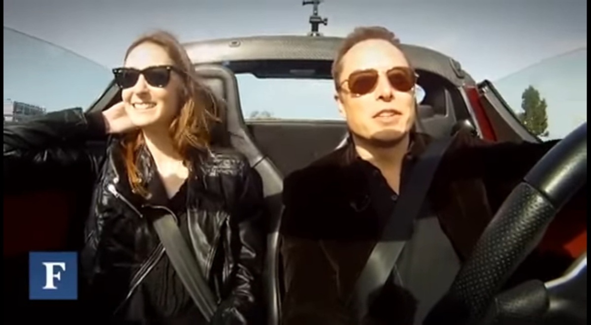В спорткаре Tesla Roadster.