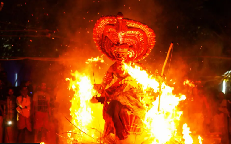 Танцор проходит через арку с горящими поленьями