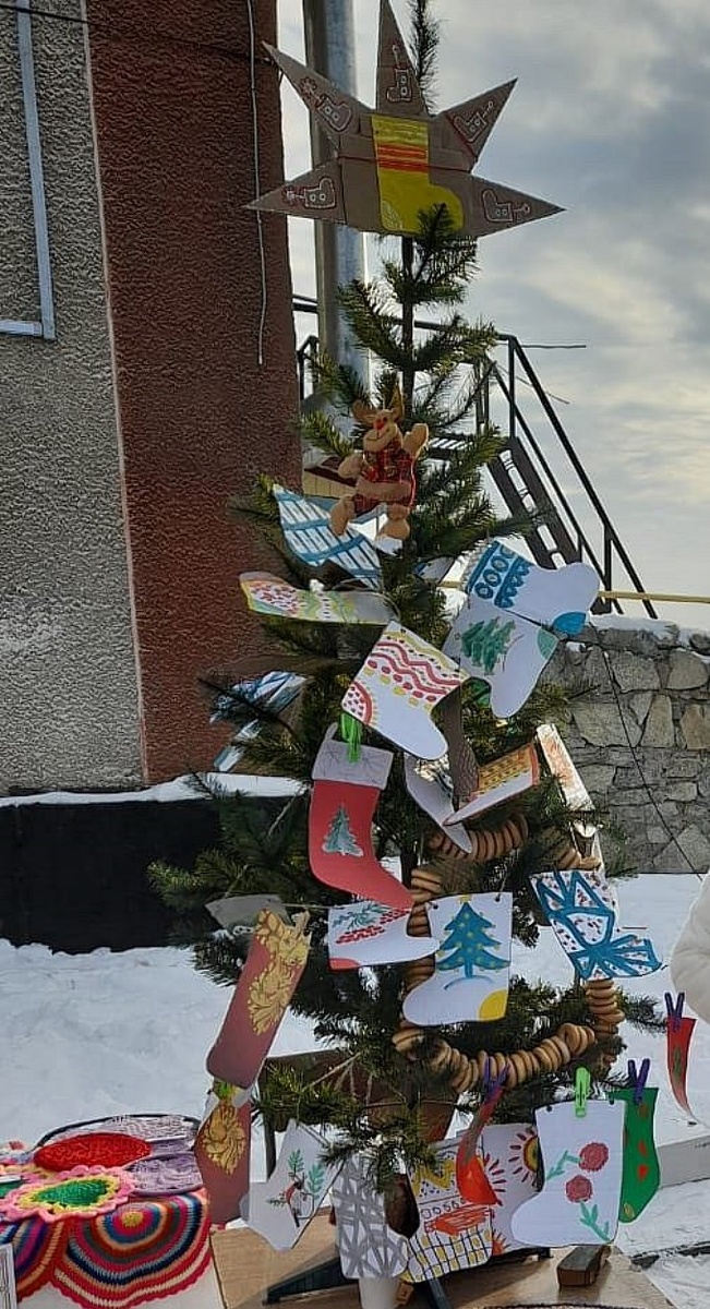 Декоративная ёлочка, украшенная гирляндами и игрушками-валенками