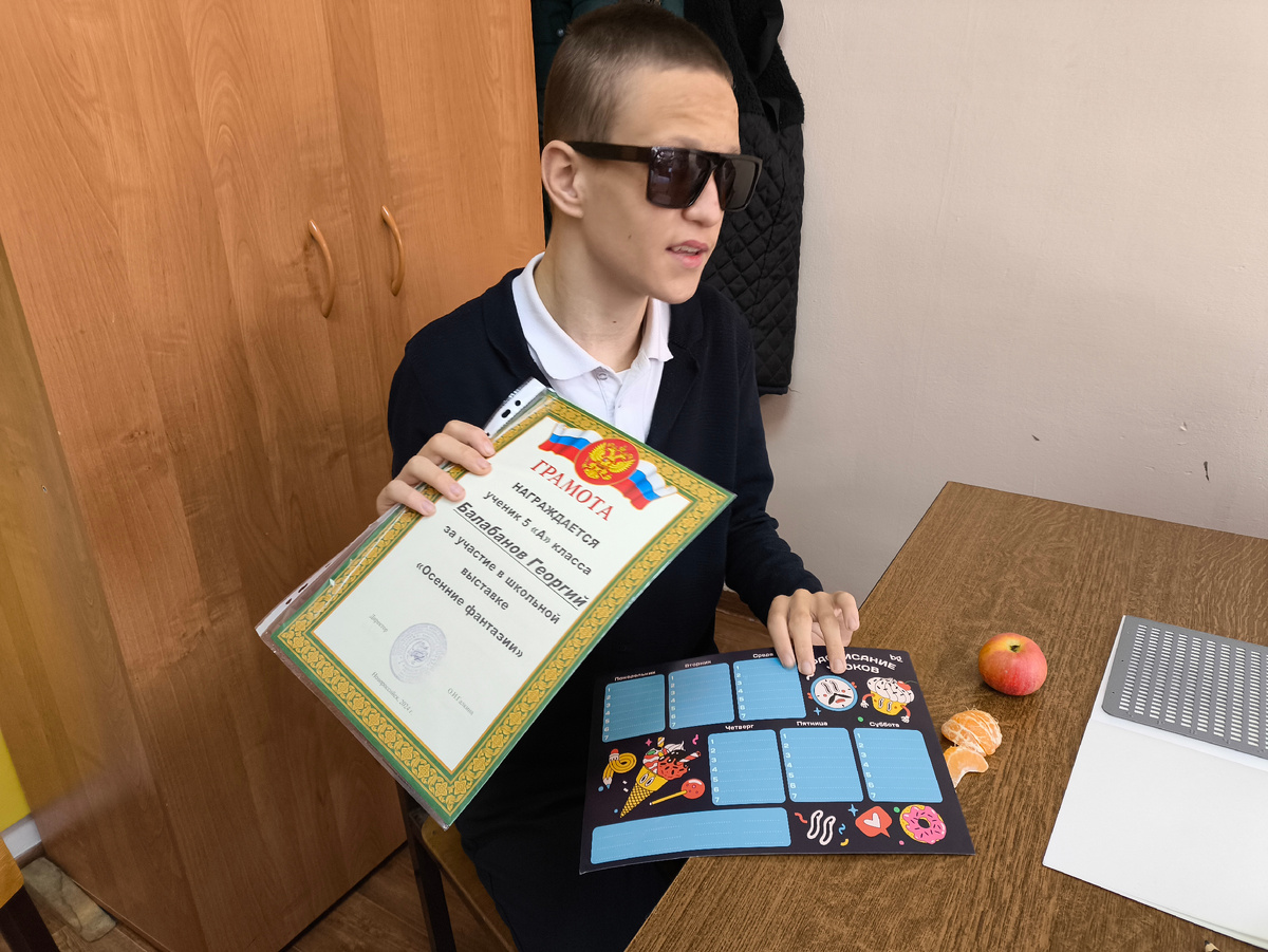 Тифлокомментарий. Гошке сегодня грамоту вручили и подарок за участие в конкурсе. Гошка сидит за партой и небрежно держит грамоту. Вообще он ей размахивал, как фланом