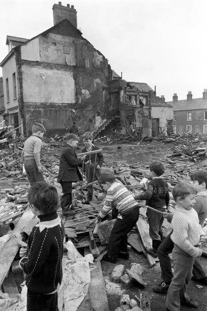 Дети достают детскую кроватку из-под обломков бара «МакГурк» на Норт-Куин-стрит в Белфасте