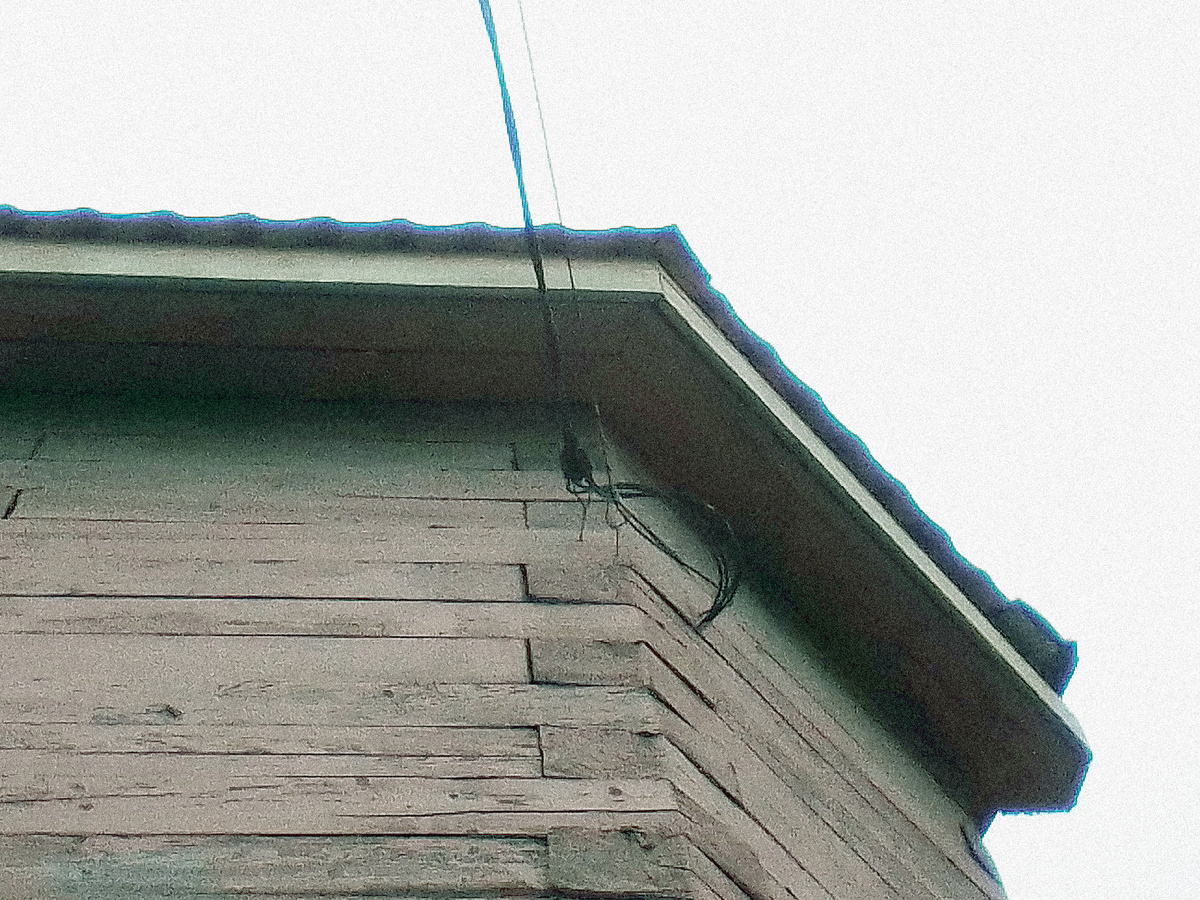 Крюк, удерживающий оптоволоконный кабель на стене частного дома. 