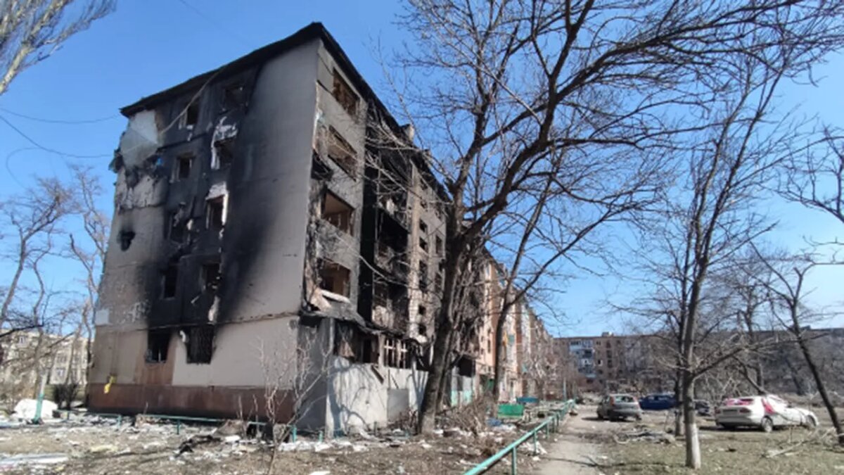    Поврежденный многоквартирный дом в Мариуполе