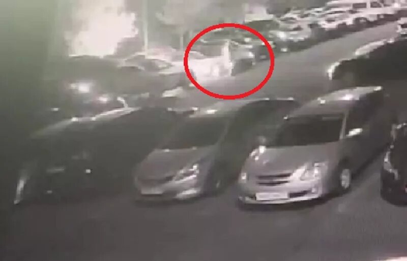 Мужчина отходит от подожжённой иномарки.
