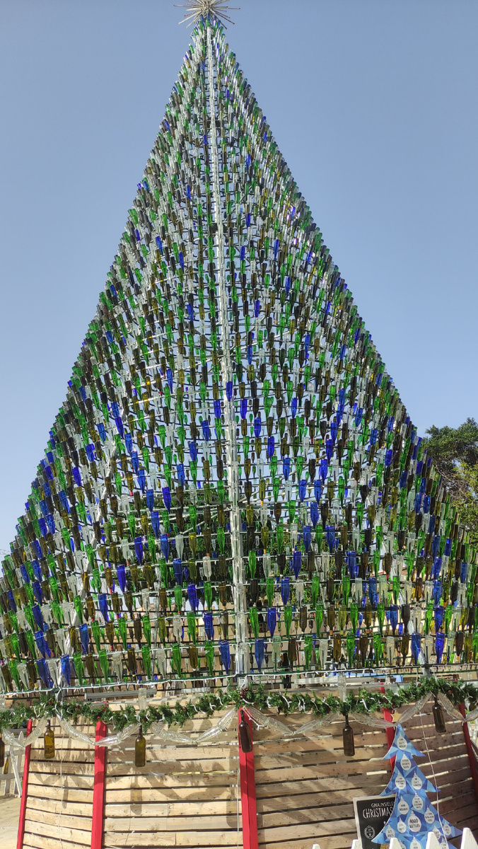 На этой ёлке всё из стеклянных бутыок, даже гирлянды. Специально размещаю фото с разного расстояния, чтобы можно было оценить масштабы конструкции.