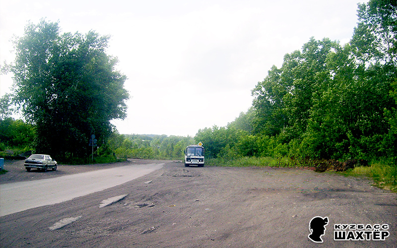 Фото автора. Там, за автобусов видна развилка дорог – та самая, которая имеет самое непосредственное отношение к истории с Иришкой. На дороге, уходящей вправо, через десяток метров от развилки был ж/д переезд с подъездными путями. К нынешней истории не имеет никакого отношения, а лишь косвенно иллюстрирует публикацию. Пышной зелени справа не было, слева когда-то располагалась школа, в которой я учился с 1-го по 8-й классы.