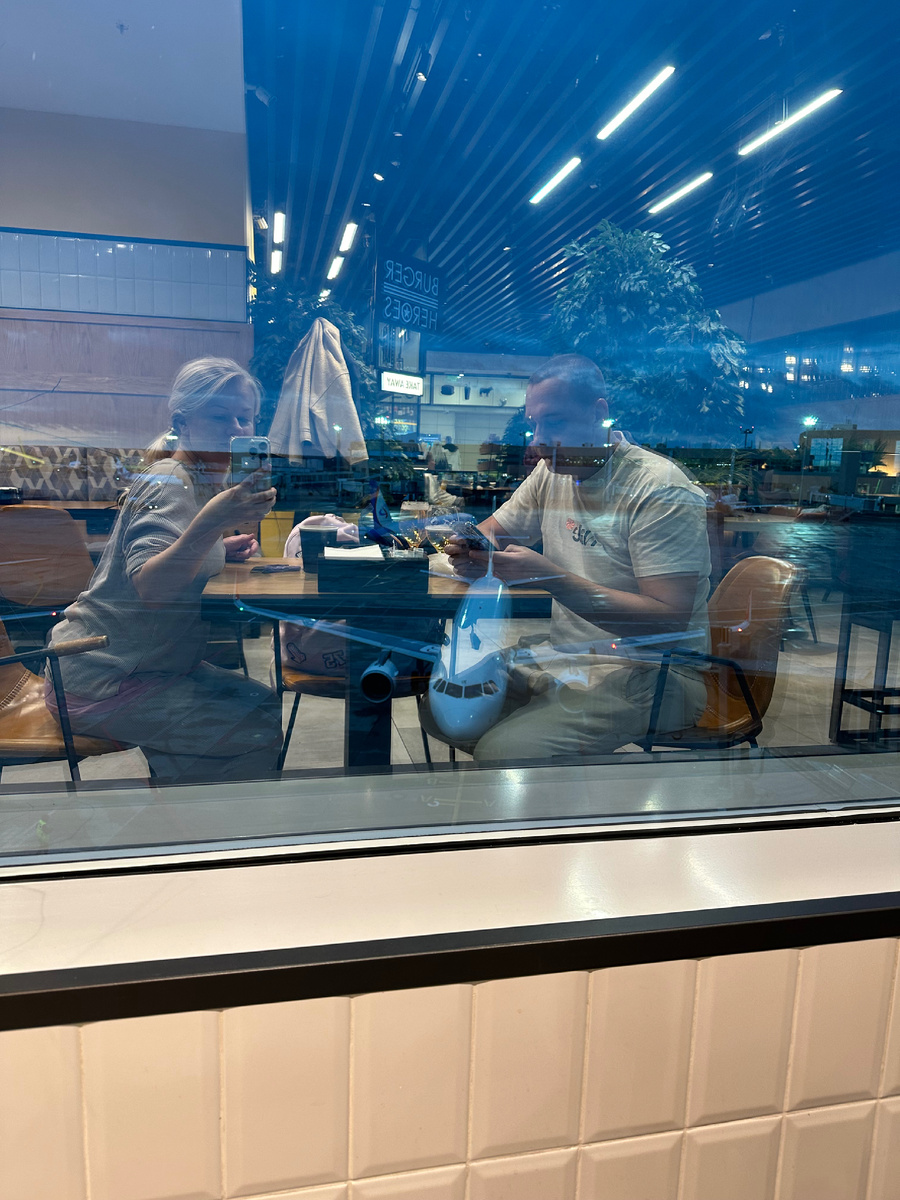 Мы в аэропорту в ожидании рейса в кафешке с видом на самолеты