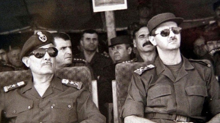 Избранный президент генерал-лейтенант Башар аль-Асад (справа) на военных учениях с Али Асланом, начальником штаба сирийской армии, 12 июля 2000 года в Сирии. SANA через AP