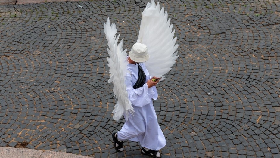    Парень в костюме ангела на ходу ведёт переписку. Автор фото: Михаил Тихонов / "Деловой Петербург"