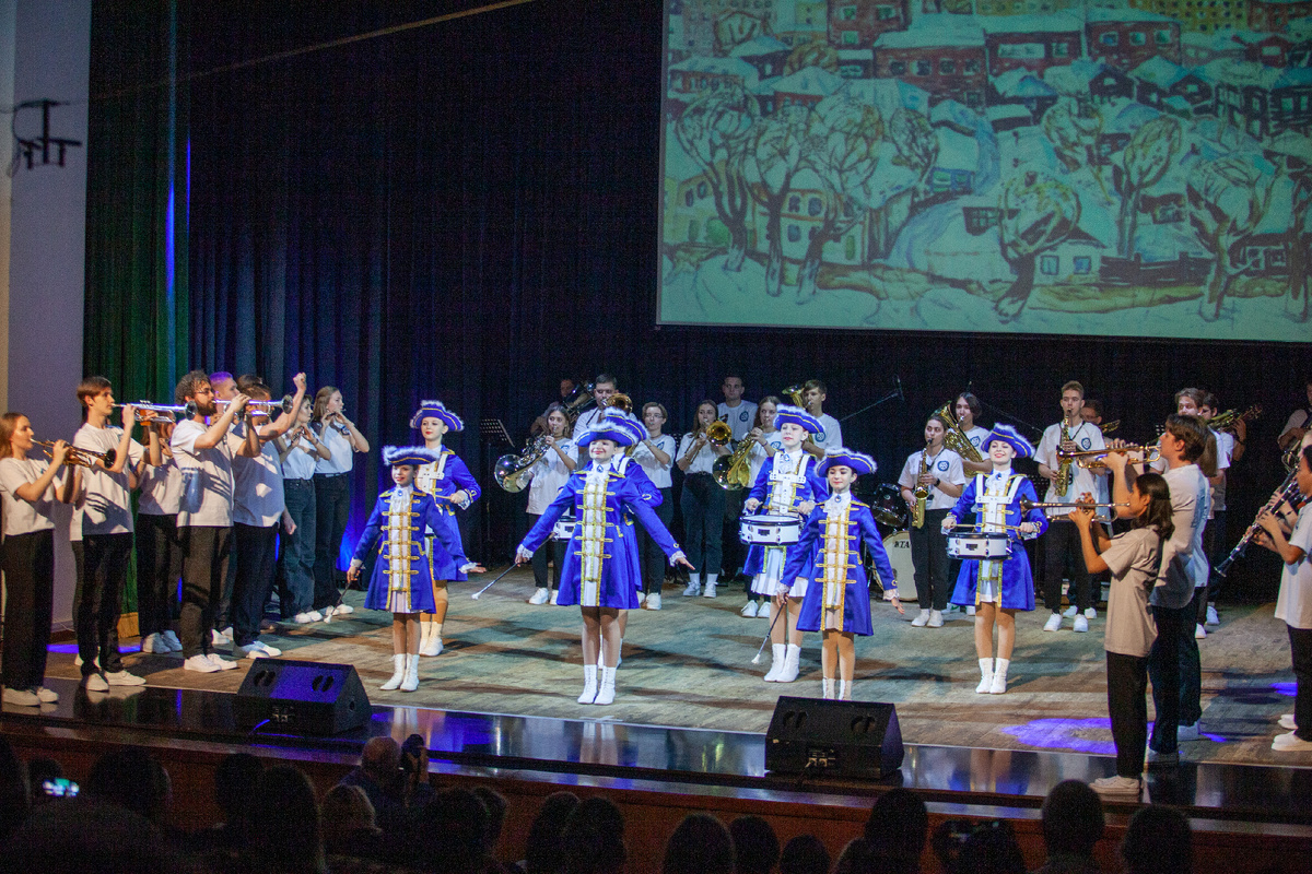 На сцене духовой оркестр СГИИ - дирижер Евгений Саблин, и коллектив мажореток- барабанщиц «Аквамарин».