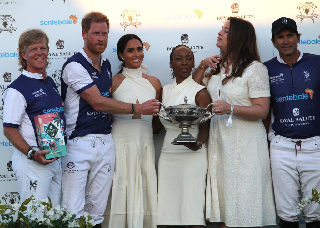 Герцогиня Сассекская вручает трофей своему мужу, герцогу Сассекскому, после того, как его команда Royal Salute Sentebale Team одержала победу над командой Grand Champions в турнире Royal Salute Polo Challenge в пользу Сентебале в Национальном центре поло USPA в Веллингтоне, штат Флорида, США. Дата съемки: пятница, 12 апреля 2024 года. Фото Yaroslav Sabitov/PA Images via Getty Images
