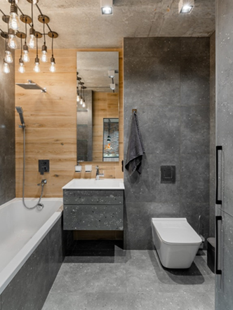 При оформлении ванной комнаты лучше всего подойдет керамическая плитка, имитирующая бетон, или влагостойкие панели, стилизованные под дерево.