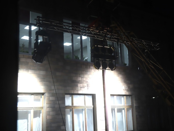     Снаружи здания - подъемный кран с прожекторами